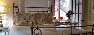 Accommodations at the Umpleby House B&B, view of room with antique iron bed and open door leading to balcony
